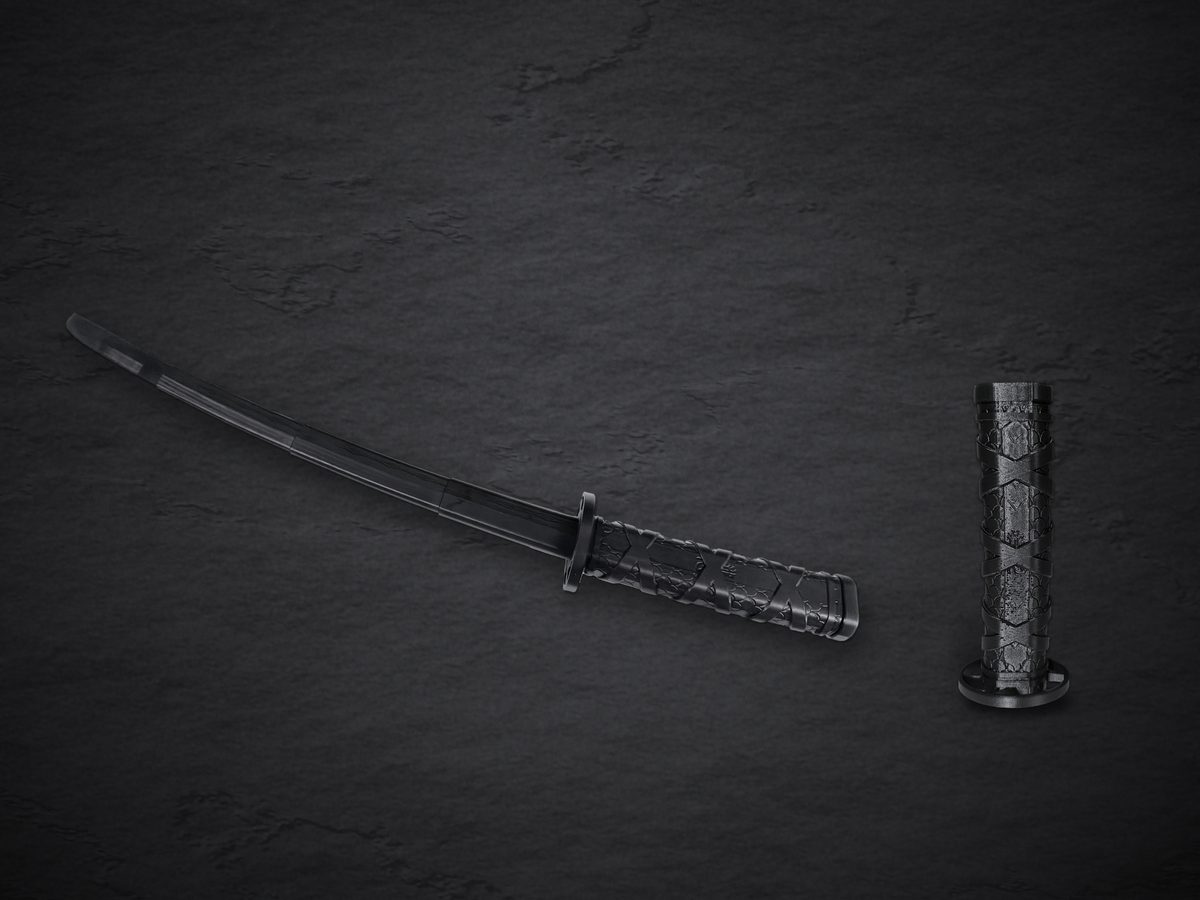 Two Fukutsu katanas on dark slate: one fully extended with its curved four-section blade, one fully collapsed and standing on its guard