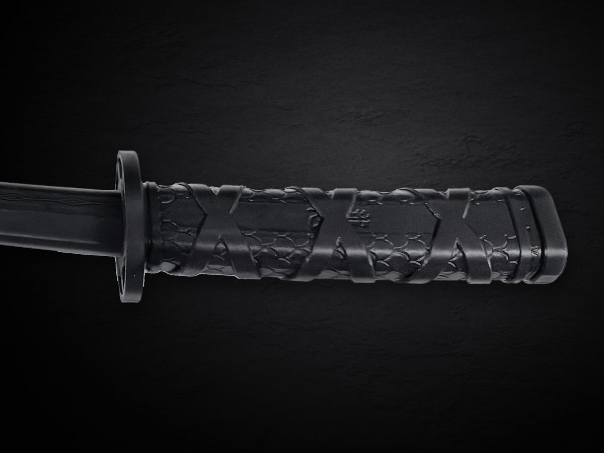 Close view of the black handle: raised diagonal wrap over a scale-textured grip, with the round guard at the base of the blade