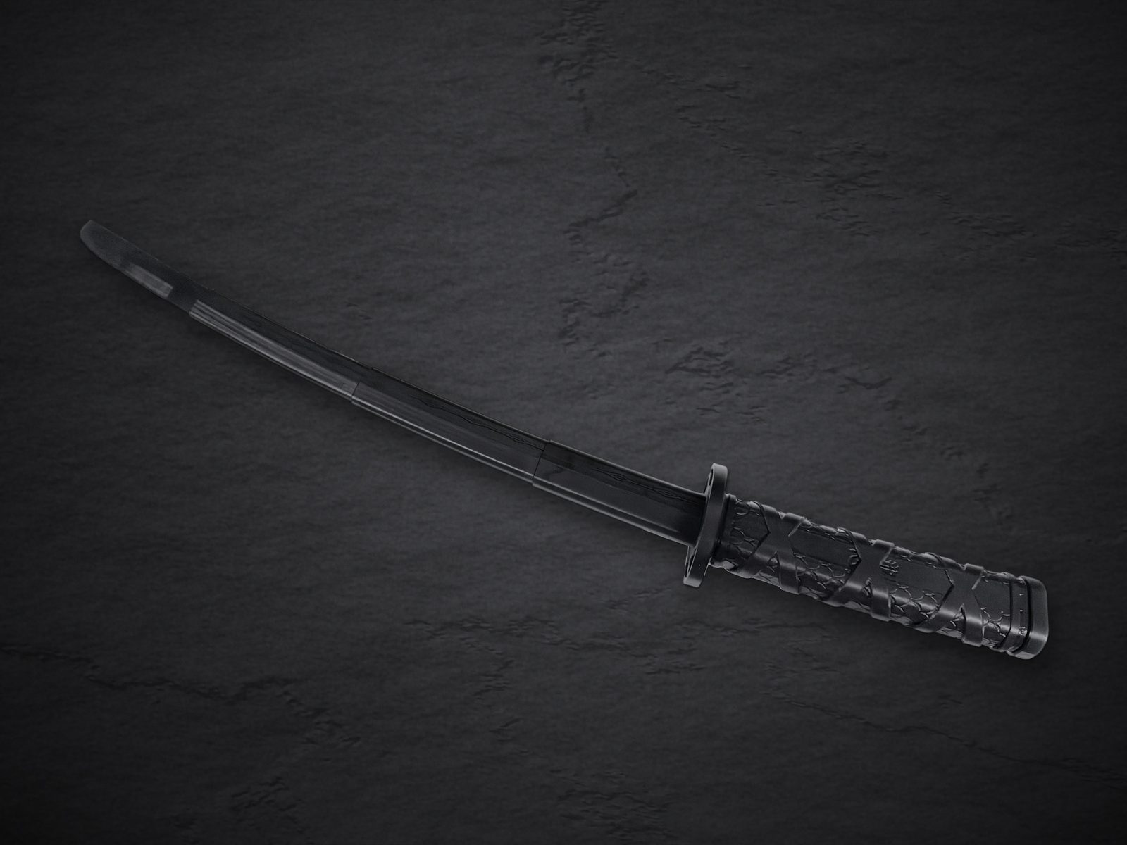 The black Fukutsu katana fully extended on dark slate: four-section curved blade, round guard, and wrapped handle